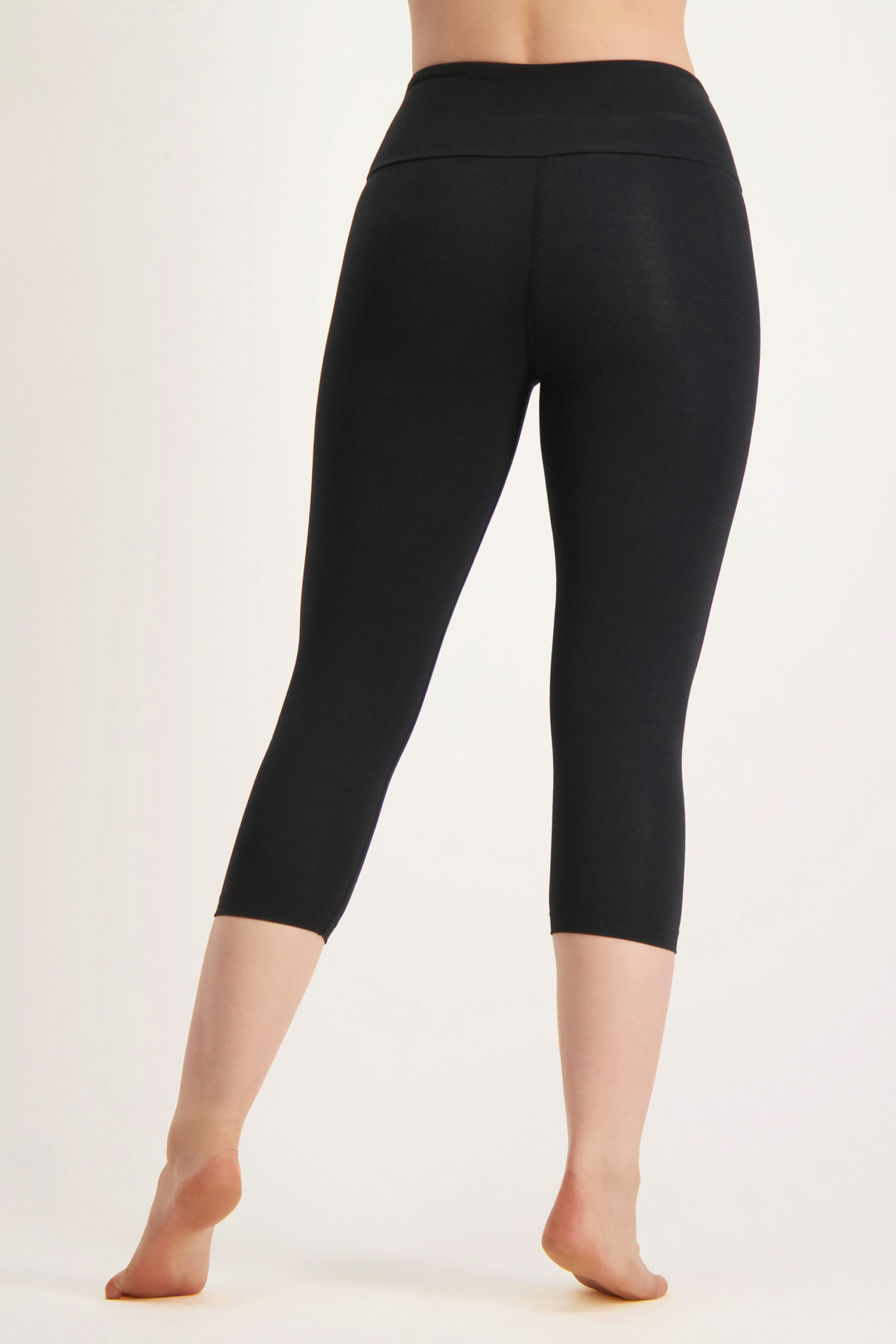 https://www.urban-goddess.com/wp-content/uploads/2022/12/products-Satya-capri-leggings-urban-black-13135501-back-model-scaled-1.jpg